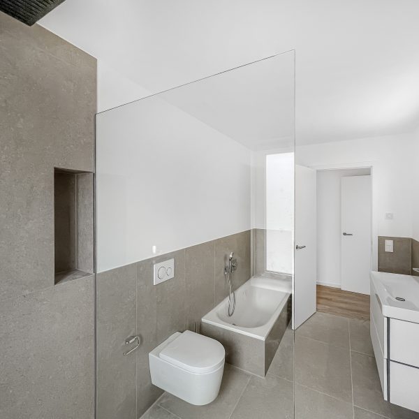 Badezimmer mit bodenebener Dusche und Badewanne