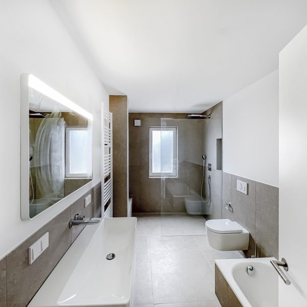 Badezimmer mit bodenebener Dusche und Badewanne